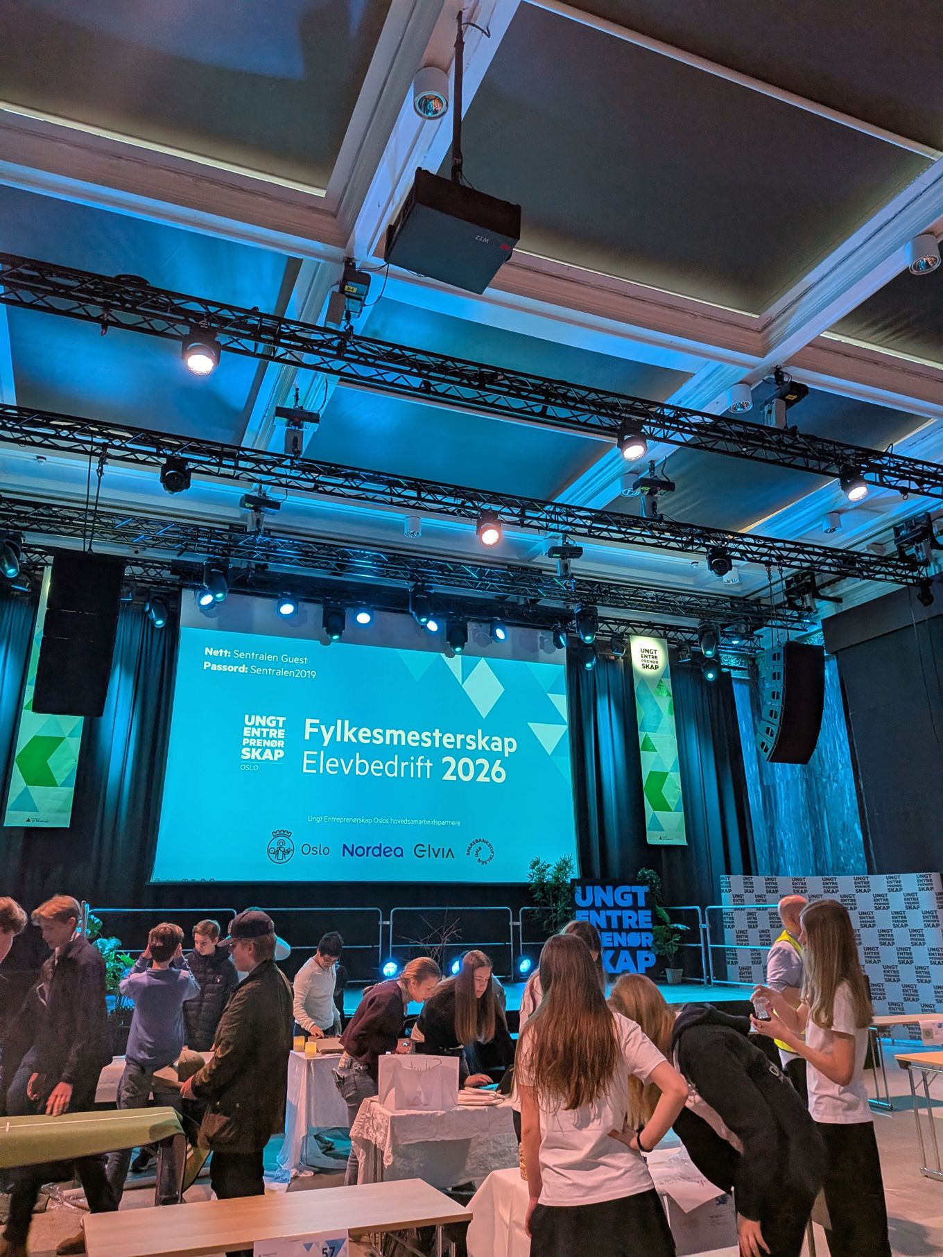 En gruppe mennesker i et rom med en stor skjerm