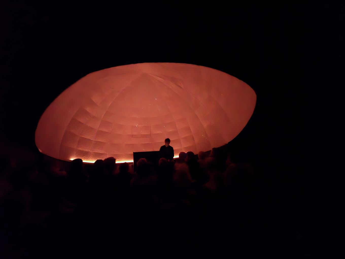 en gruppe mennesker foran en stor rød sirkel med lys en gruppe mennesker foran en stor rød sirkel med lys