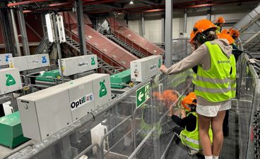 en gruppe mennesker iført sikkerhetsvester som jobber på en maskin